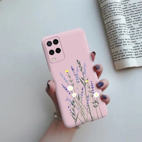 a woman holding a pink phone case with flowers on it