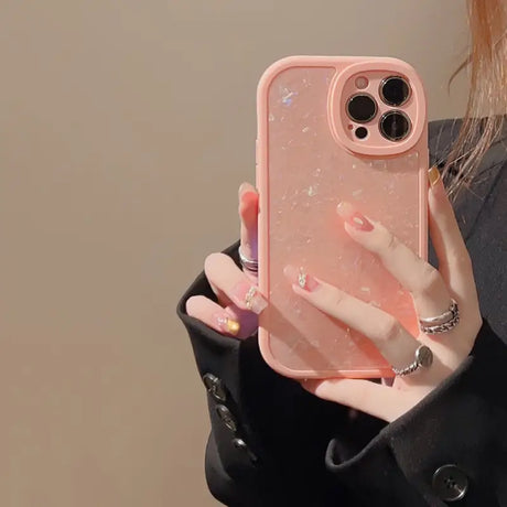 a woman holding a pink phone case