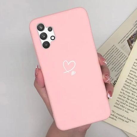 a woman holding a pink phone case with a heart on it