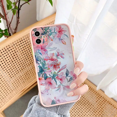 a woman holding a pink phone case with flowers on it