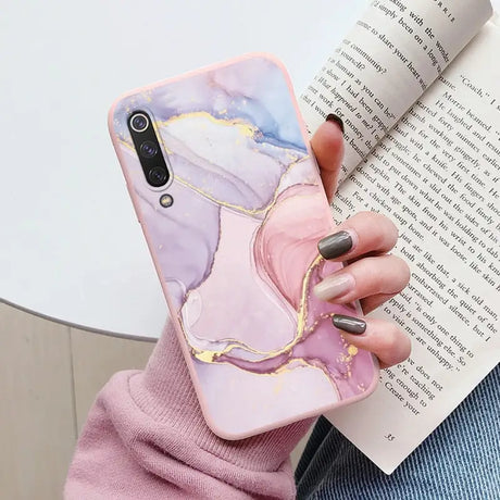 a woman holding a book and a phone case