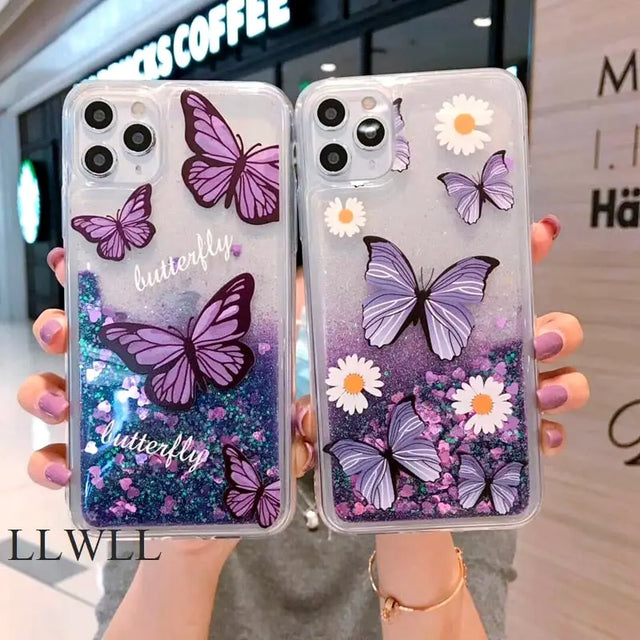 a woman holding up two purple butterflies on a clear case