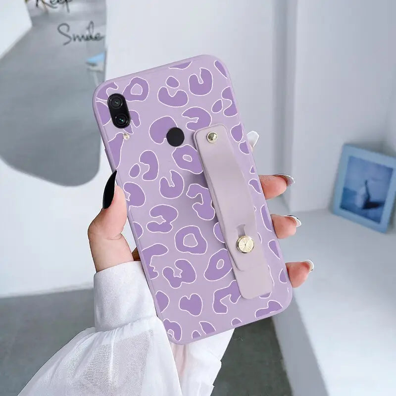 a woman holding a purple camouflage phone case
