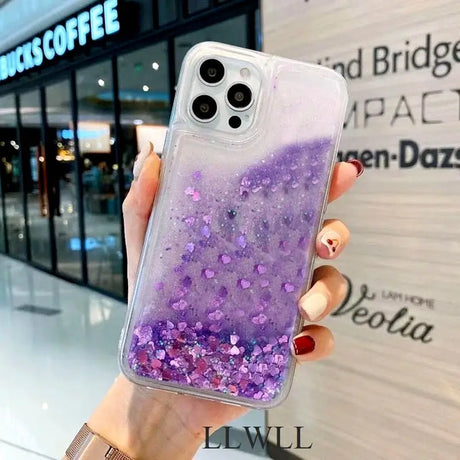 a woman holding a purple glitter phone case