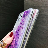 a woman holding a purple and purple liquid phone case