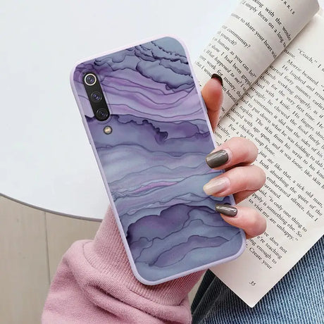 a woman holding a book and a phone case