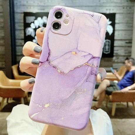 a woman holding a purple marble phone case