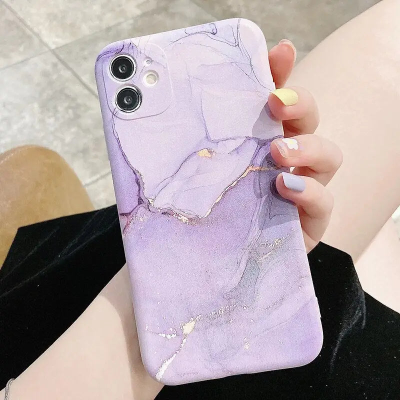 a woman holding a purple marble phone case