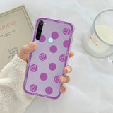 a woman holding a purple phone case with hearts on it