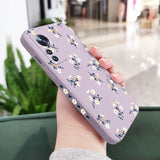 a woman holding a purple phone case with white flowers on it