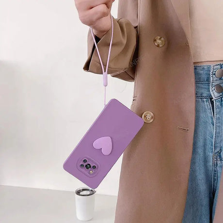 a woman holding a purple phone case