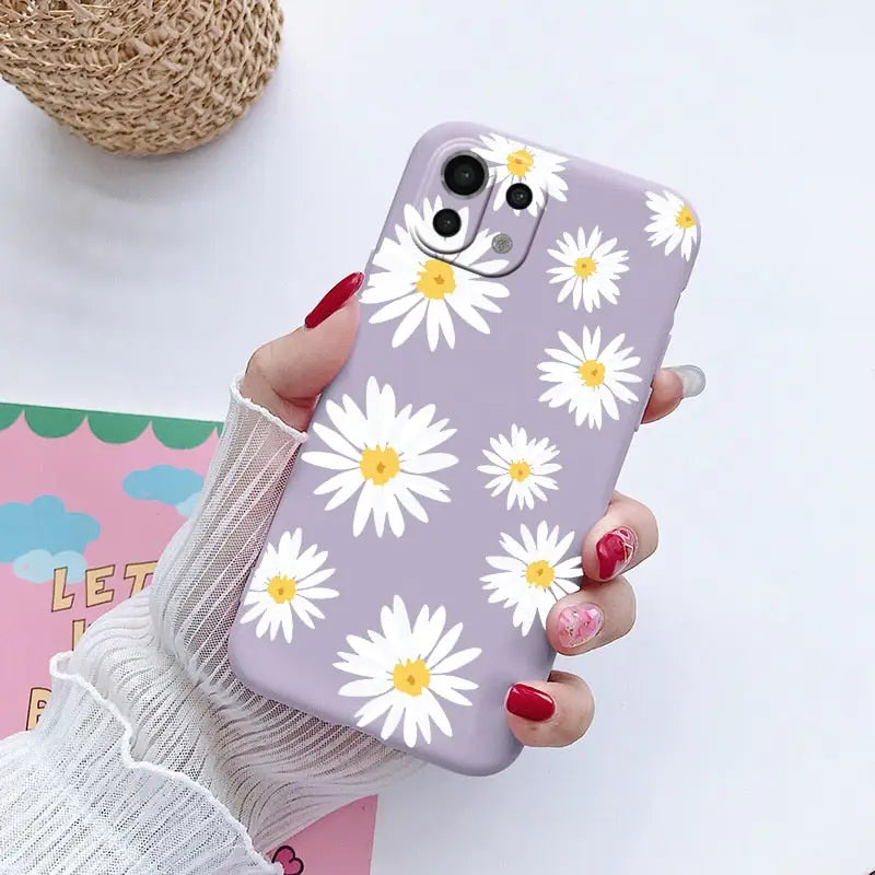 someone holding a purple phone case with white daisies on it