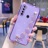 a woman holding a purple phone case with a heart ring