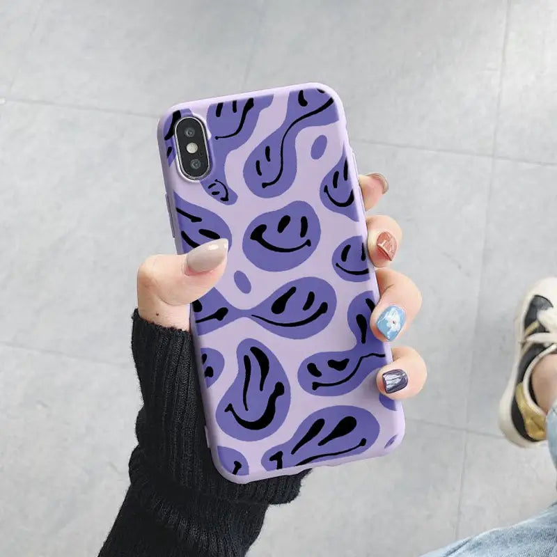 a purple and black phone case with a smiley face pattern