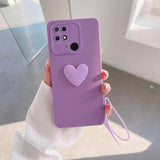 a woman holding a purple phone case with a heart on it