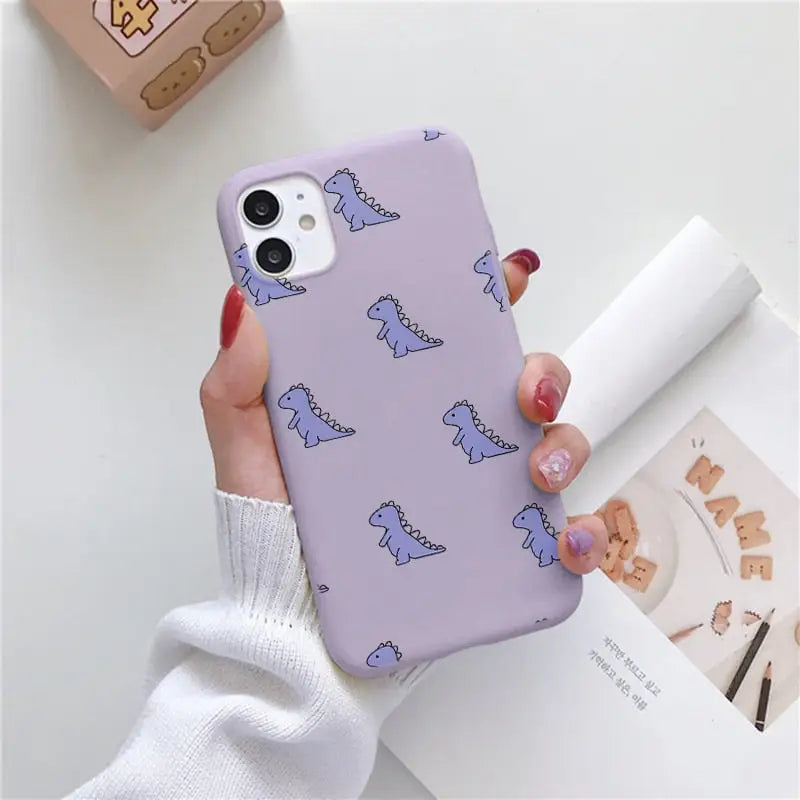 a woman holding a purple phone case with a pattern on it