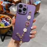 a woman holding a purple phone case with a chain attached to it
