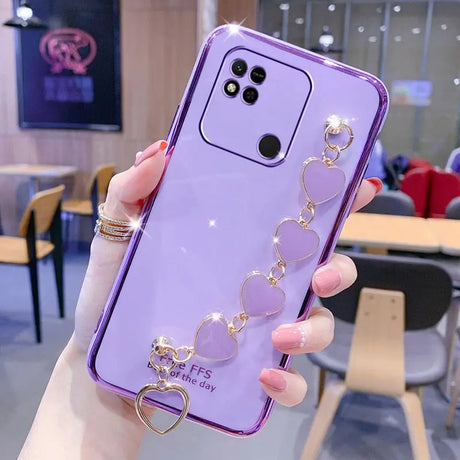 a woman holding a purple phone case with a heart ring