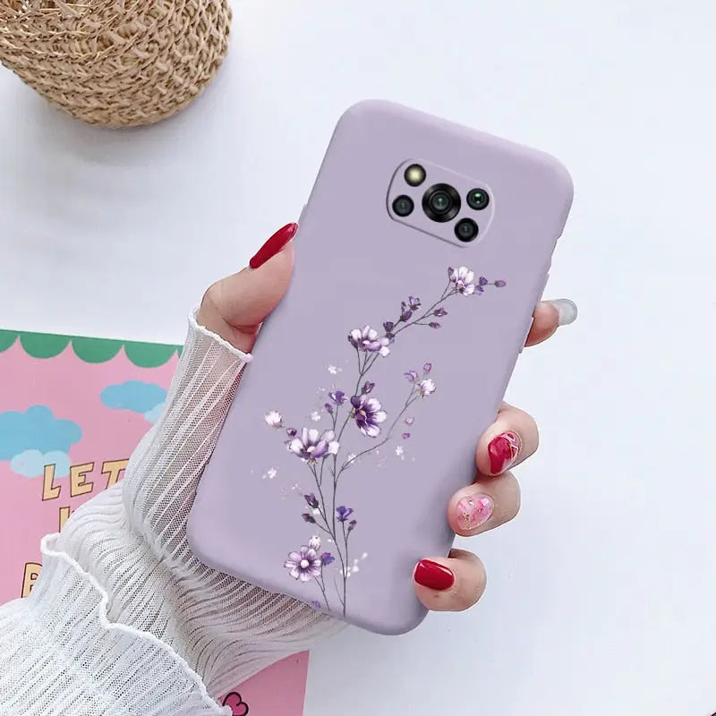 a woman holding a purple phone case with flowers on it