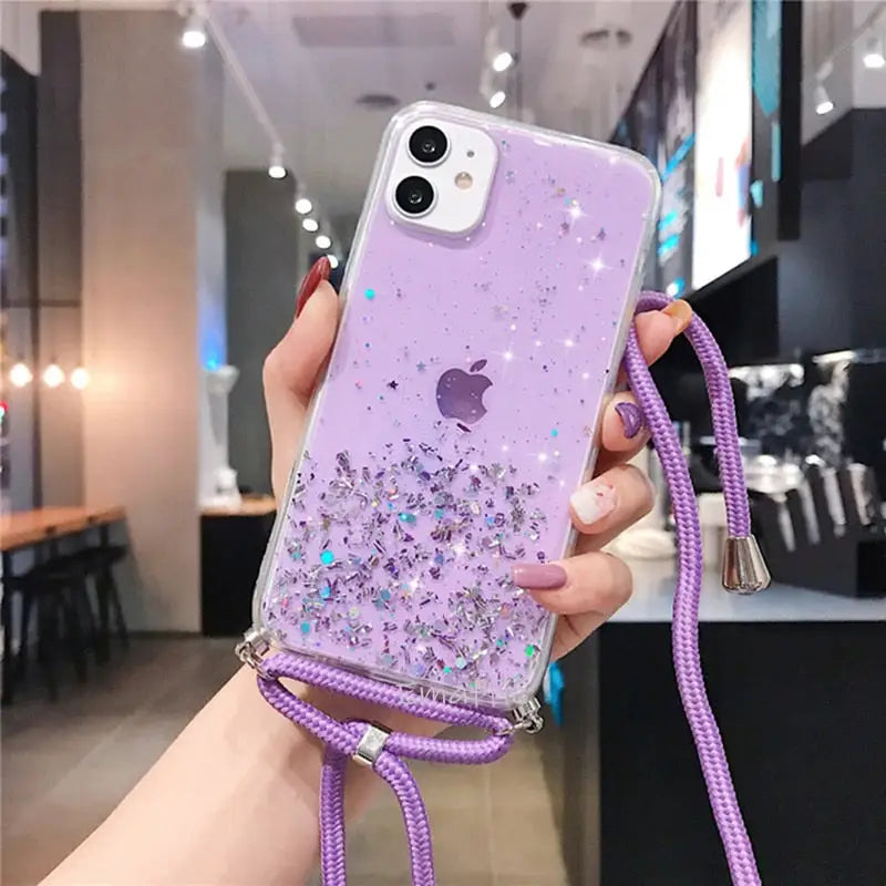 a woman holding a purple phone case with a purple and silver glitter design
