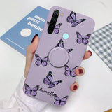 a woman holding a purple phone case with butterflies on it