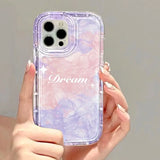 a woman holding a purple phone case with the word dream on it