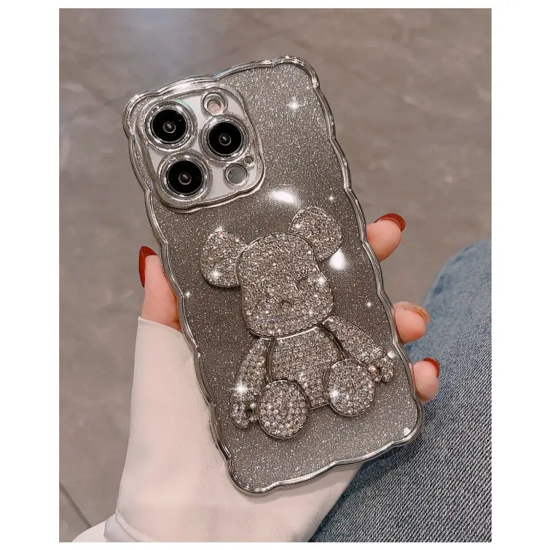 a woman holding a silver glitter iphone case