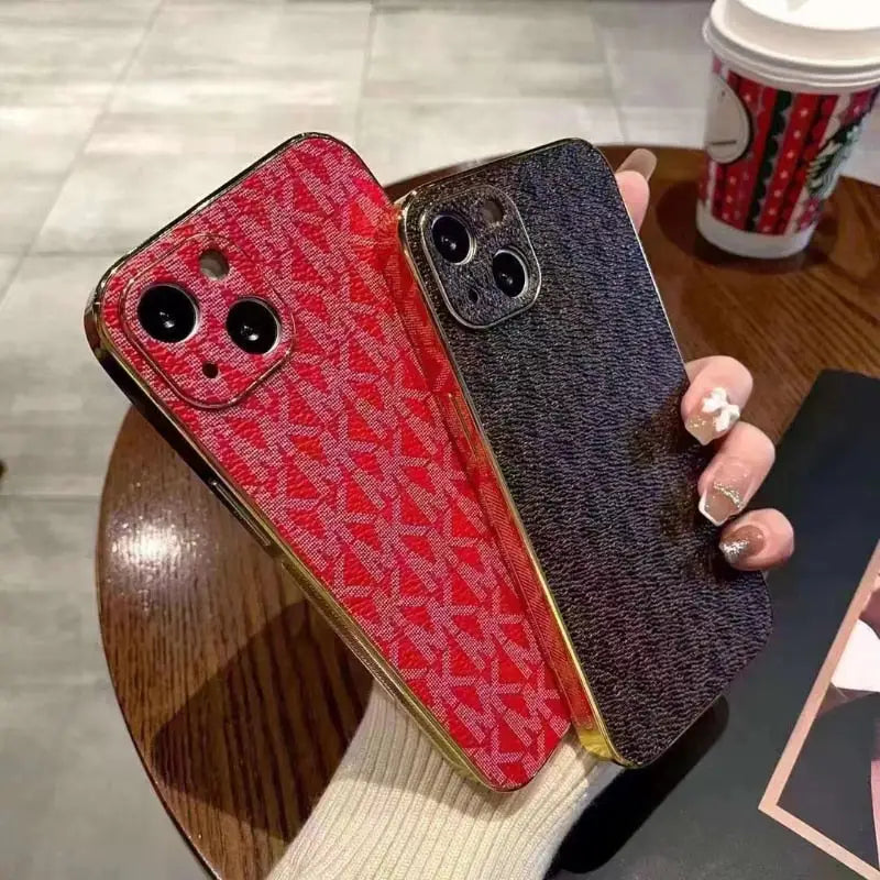 a woman holding a phone case with a red and black pattern