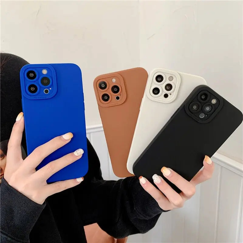 a woman holding up three different colored cases
