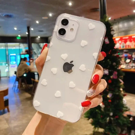 a woman holding up a white iphone case