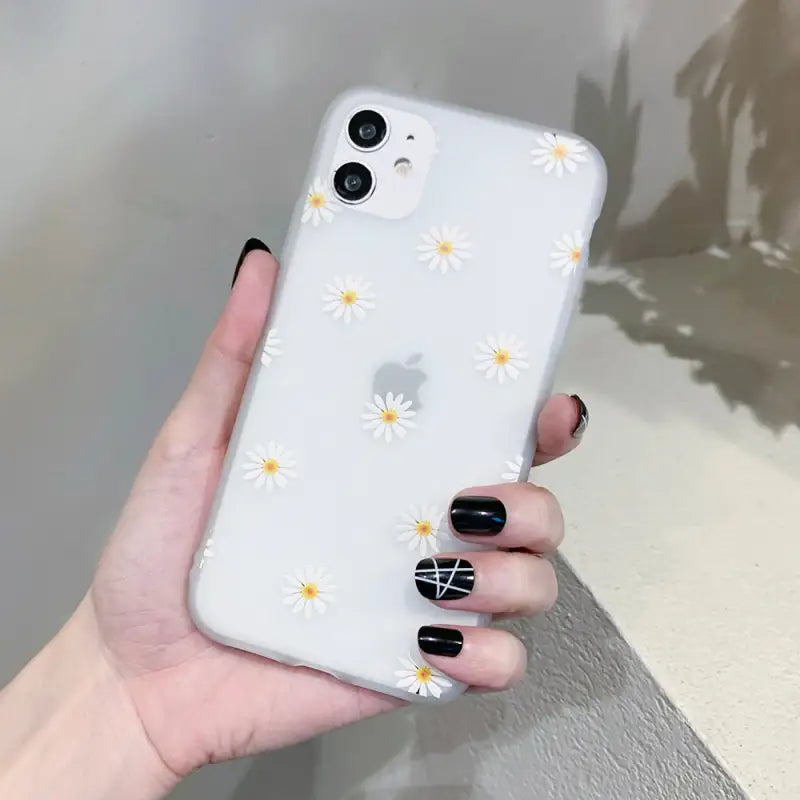 a woman holding a white phone case with yellow flowers