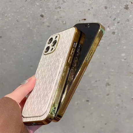 a hand holding a gold iphone case