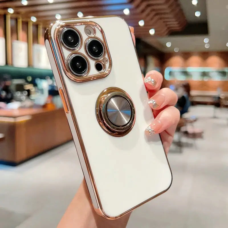 a woman holding a white iphone case with a gold ring