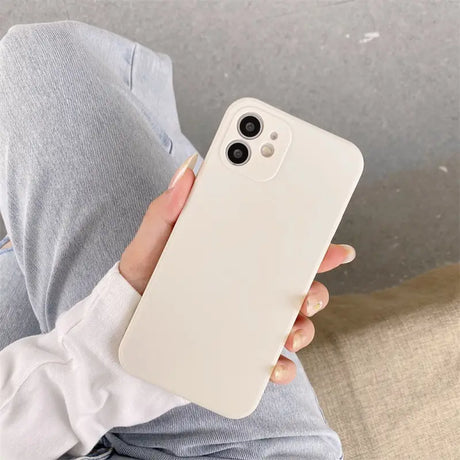 a woman holding a white iphone case