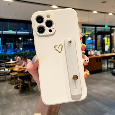 a woman holding a white phone case with a heart on it