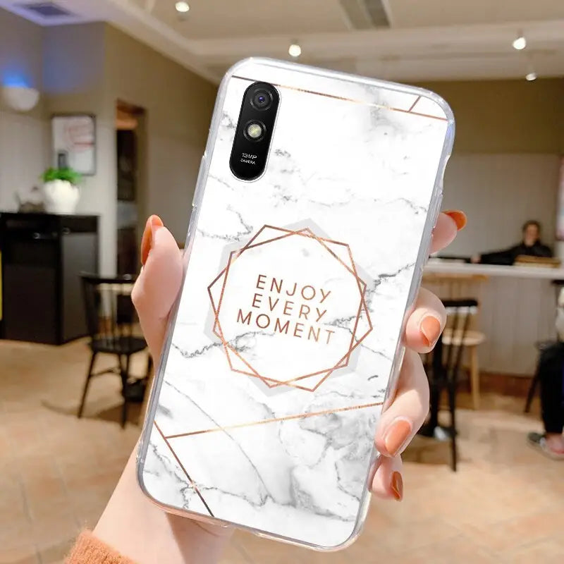 a woman holding a white marble phone case with the words enjoy moment