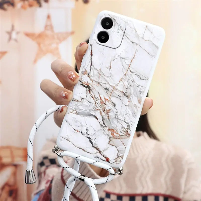 a woman holding a white phone case with marble pattern
