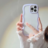 a woman holding up a white phone case