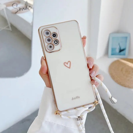 a woman holding a white phone case with a heart on it