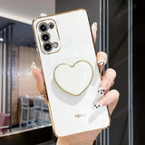 a woman holding a white phone with a gold heart on it