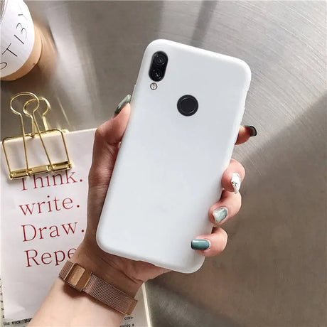 a woman holding a white phone case