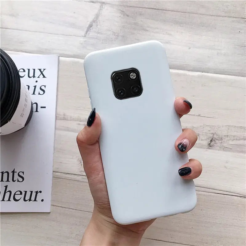 the back of a white phone case with a black phone in the background