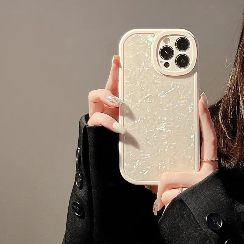 a woman holding a white phone case