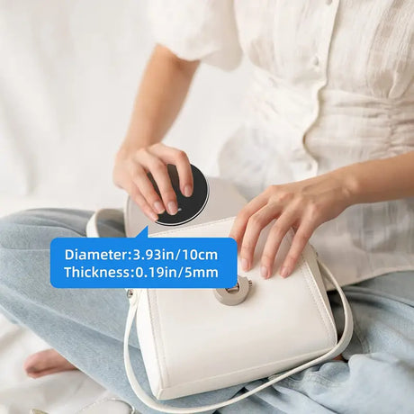 a woman sitting on a bed holding a white purse