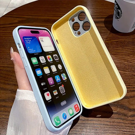 a woman holding a yellow iphone case