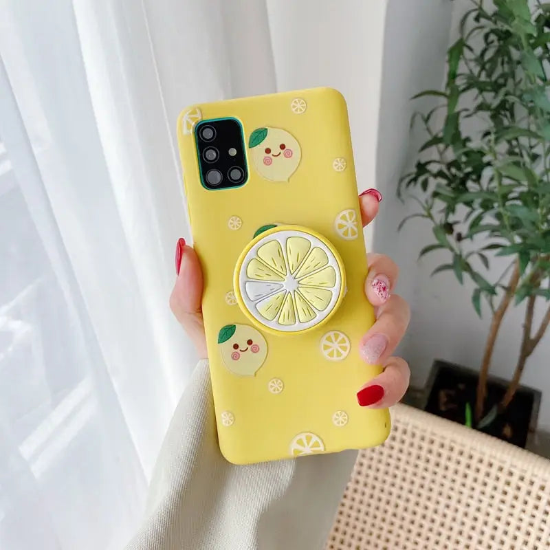 a woman holding a yellow phone case with lemons and lemons on it
