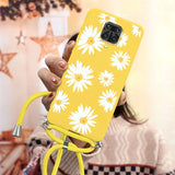 a woman holding a yellow phone case with white flowers on it