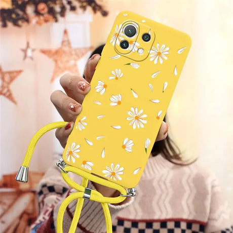 a woman holding a yellow phone case with a flower pattern