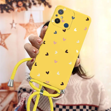 a woman holding a yellow phone case with hearts on it