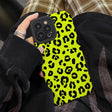 a person holding a cell case with a yellow leopard print